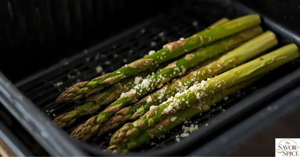 Close-up of crispy, healthy air fryer asparagus with golden tips, garnished with Parmesan cheese and lemon zest — perfect quick side dish.