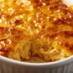 Cracker Barrel Hashbrown casserole with golden crispy top and creamy cheesy interior, served in a rustic baking dish on a wooden table